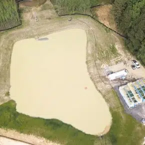 overhead of pond with open top tanks